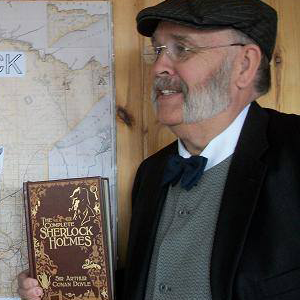 man wearing hat and holding sherlock holmes book 