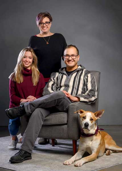 smiling family of three and dog