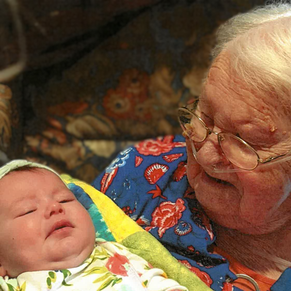 elderly woman smiling down at baby