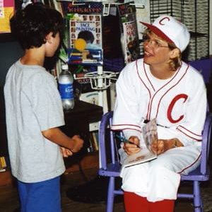 child speaking to author dresed in baseball outfit