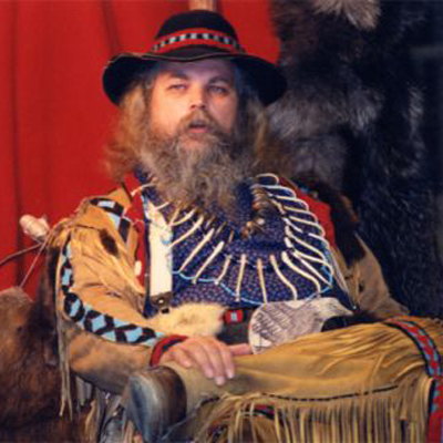 bearded man with had wearing buckskin and beaded designs