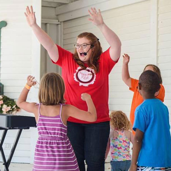 Woman wearing color red with kids waving arms