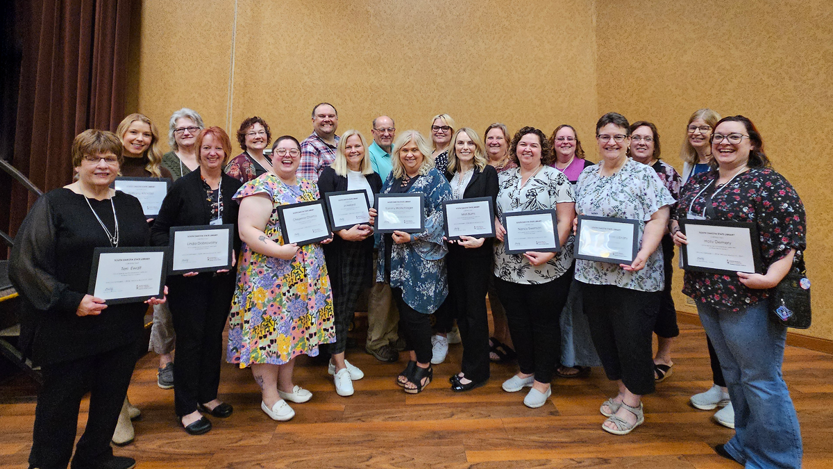 group of librarians holding certificates standing with George Seamon, State Librarian