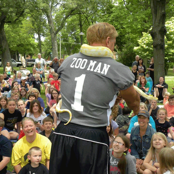 blond muscular man with zoo man shirt and yellow snake before audience